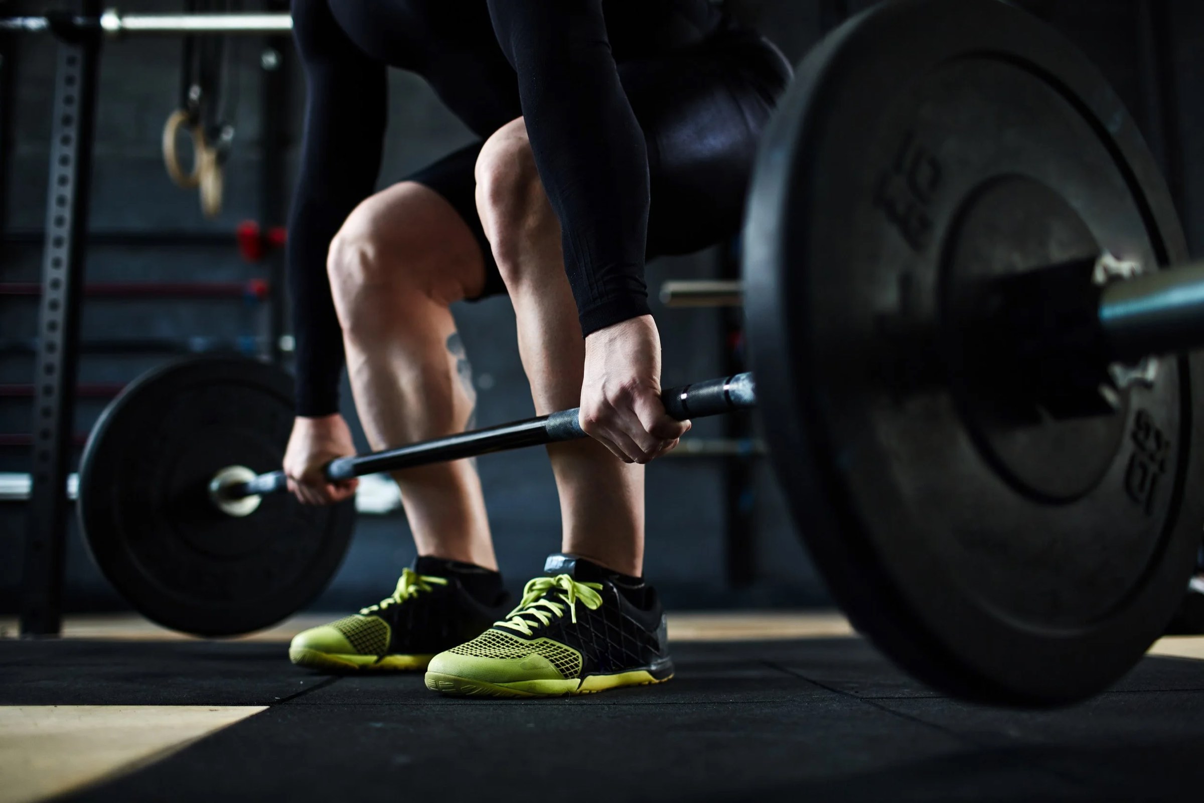 Lifter gripping a loaded barbell before a deadlift