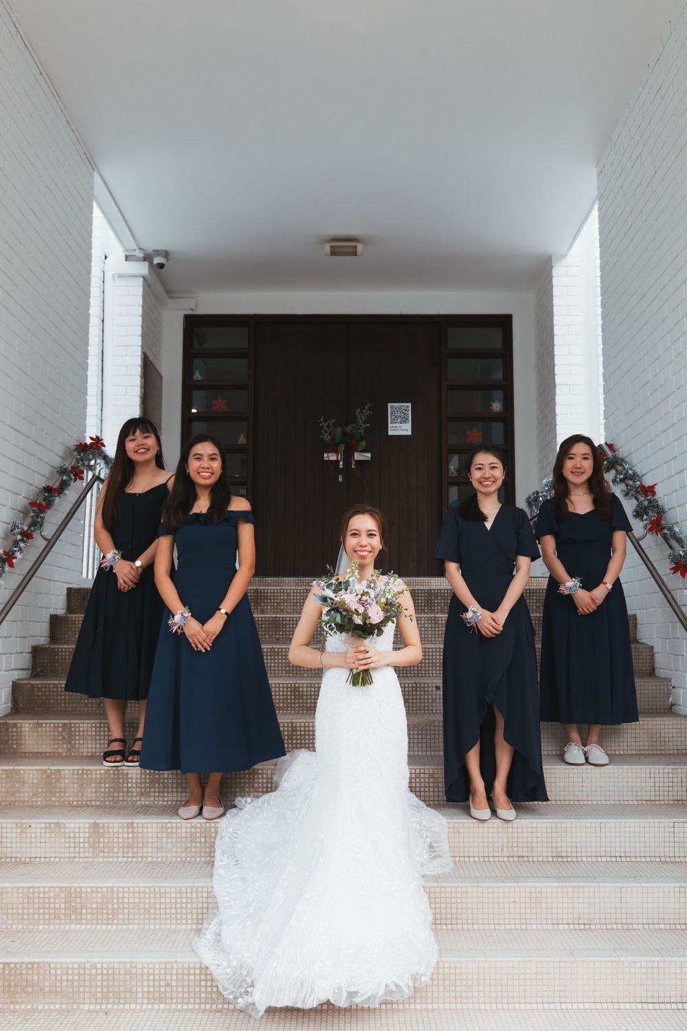Bride with her bridesmaids at the chapel doors